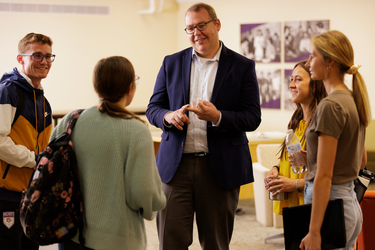 Professor engages in conversation with four students