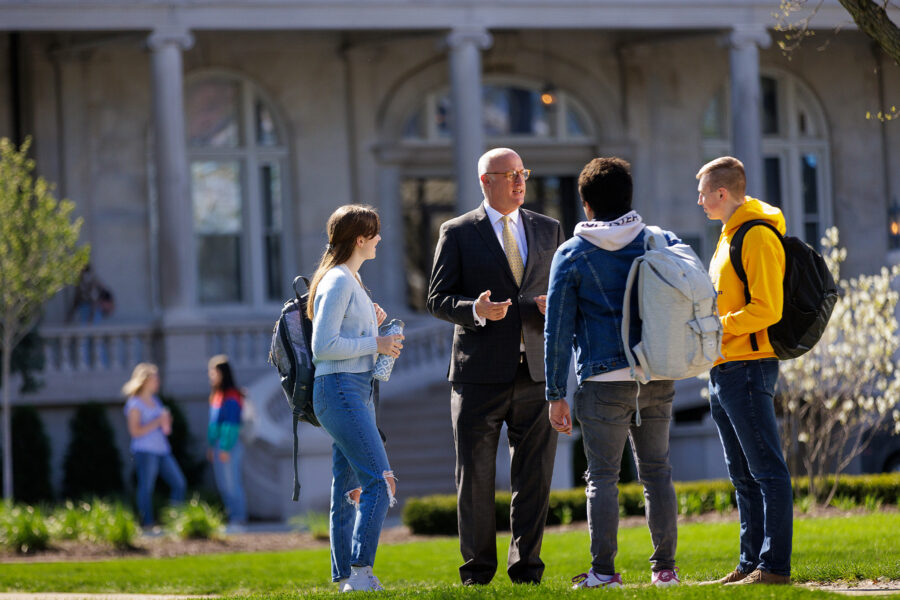 students talking with onu president in courtyard