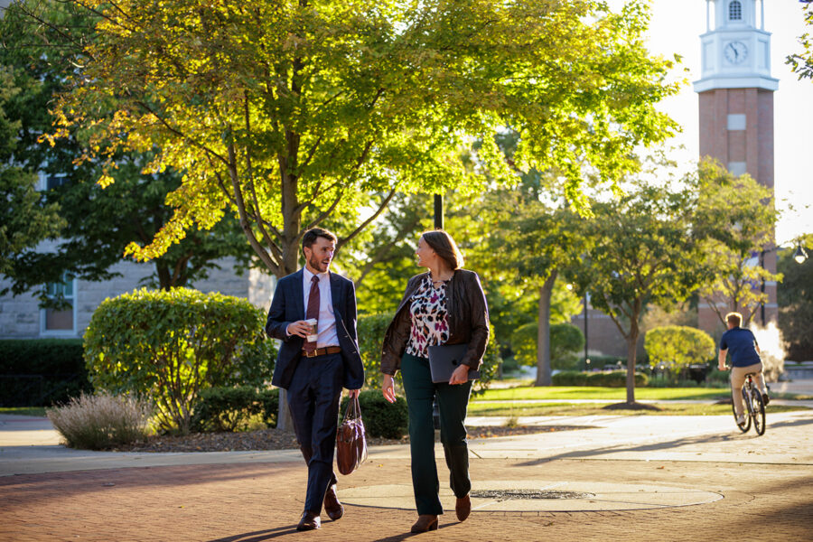 male and female walking through campus