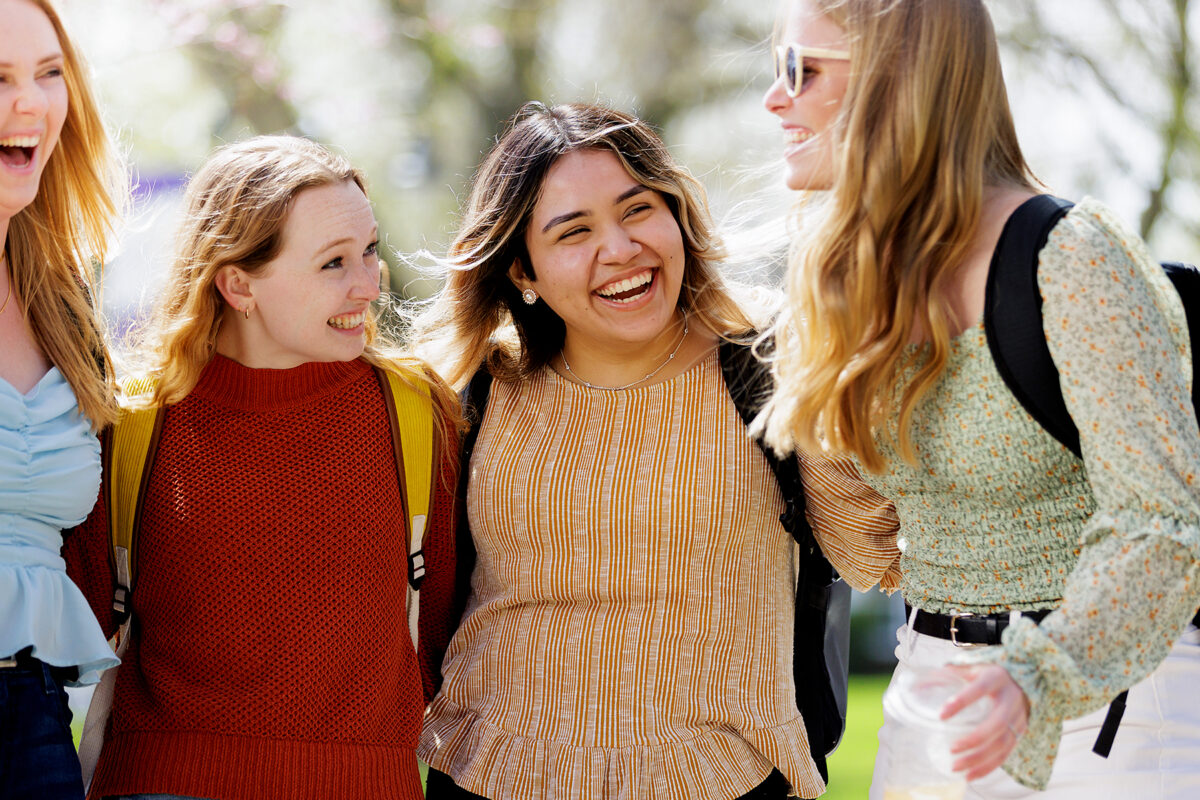 Group of smiling friends posing in the Quad