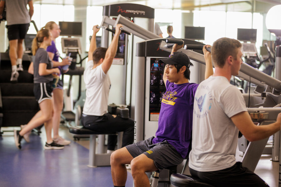 Students at the lat machines in the fitness center.