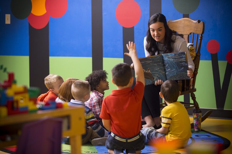 child raising hand in classroom setting