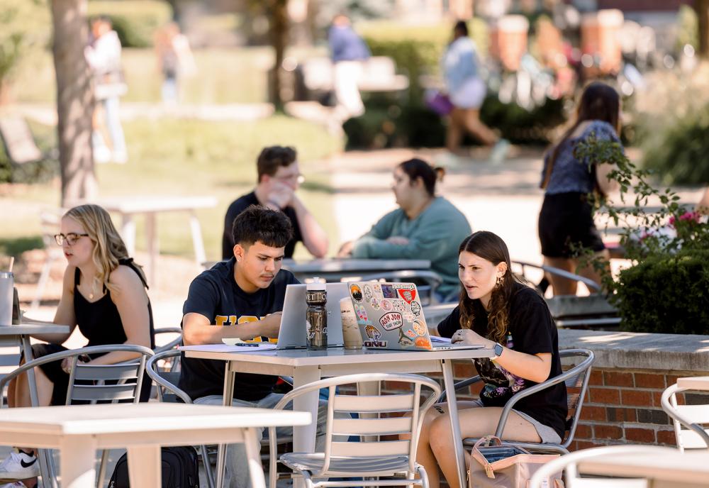 students outside sitting at tables