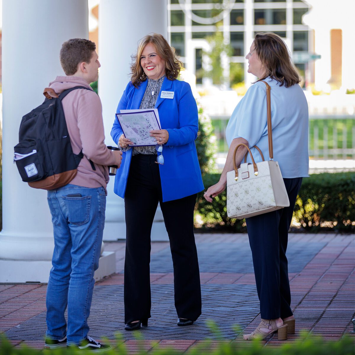 people standing in front of Admissions building
