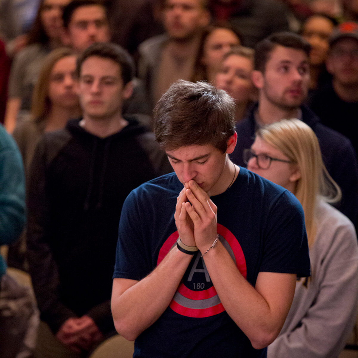 Student praying in Centennial Chapel