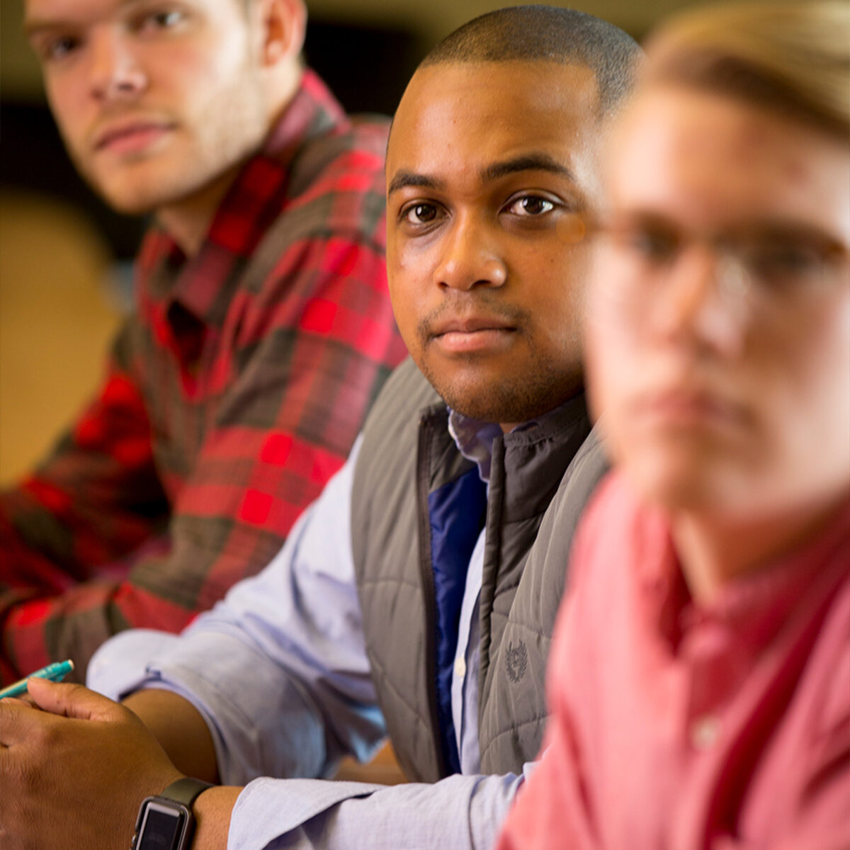 Close up of three students listening in class