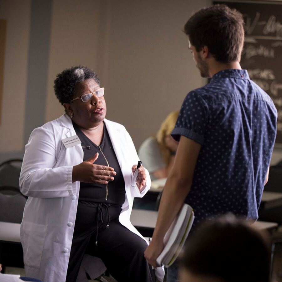 Nursing professor engages in conversation with student