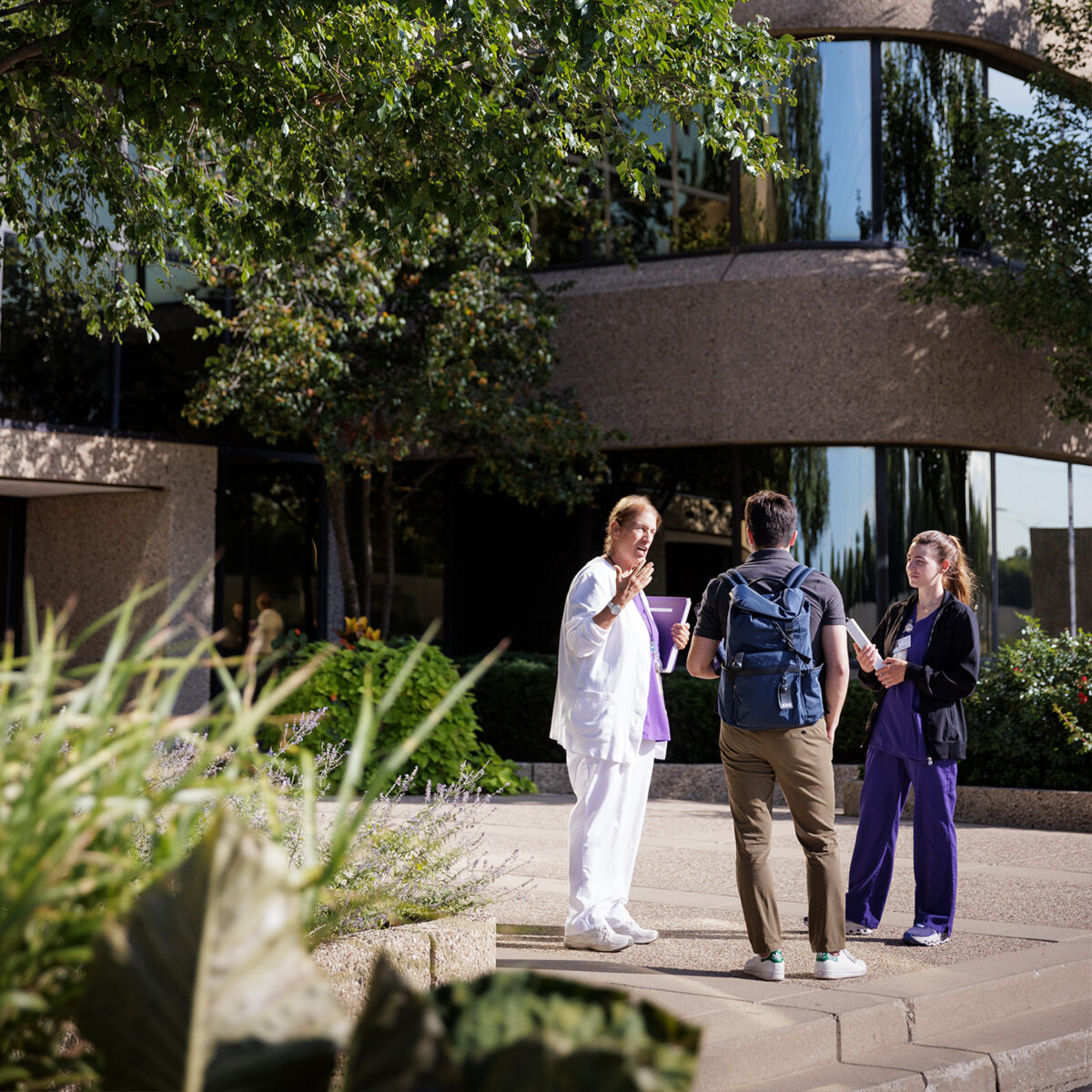 nursing prof outside building talking to students