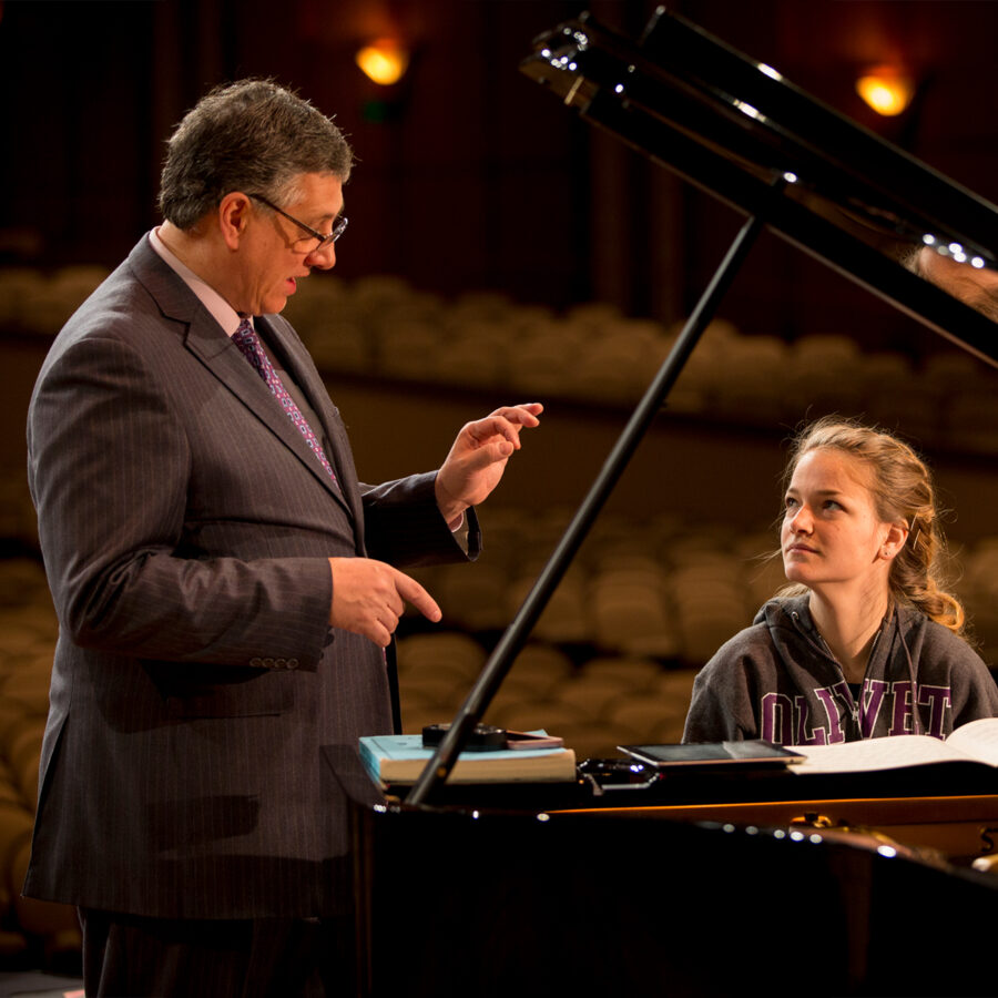 Instructor engages in conversation with piano student