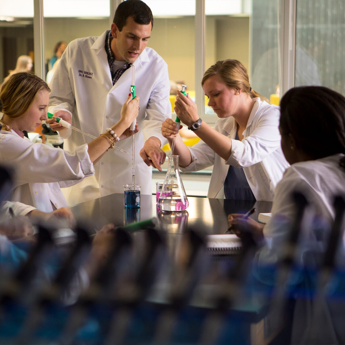 Professor and group of students conducting an experiment