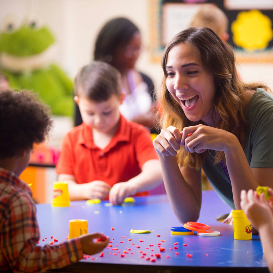 Close up photo smiling student playing with a child