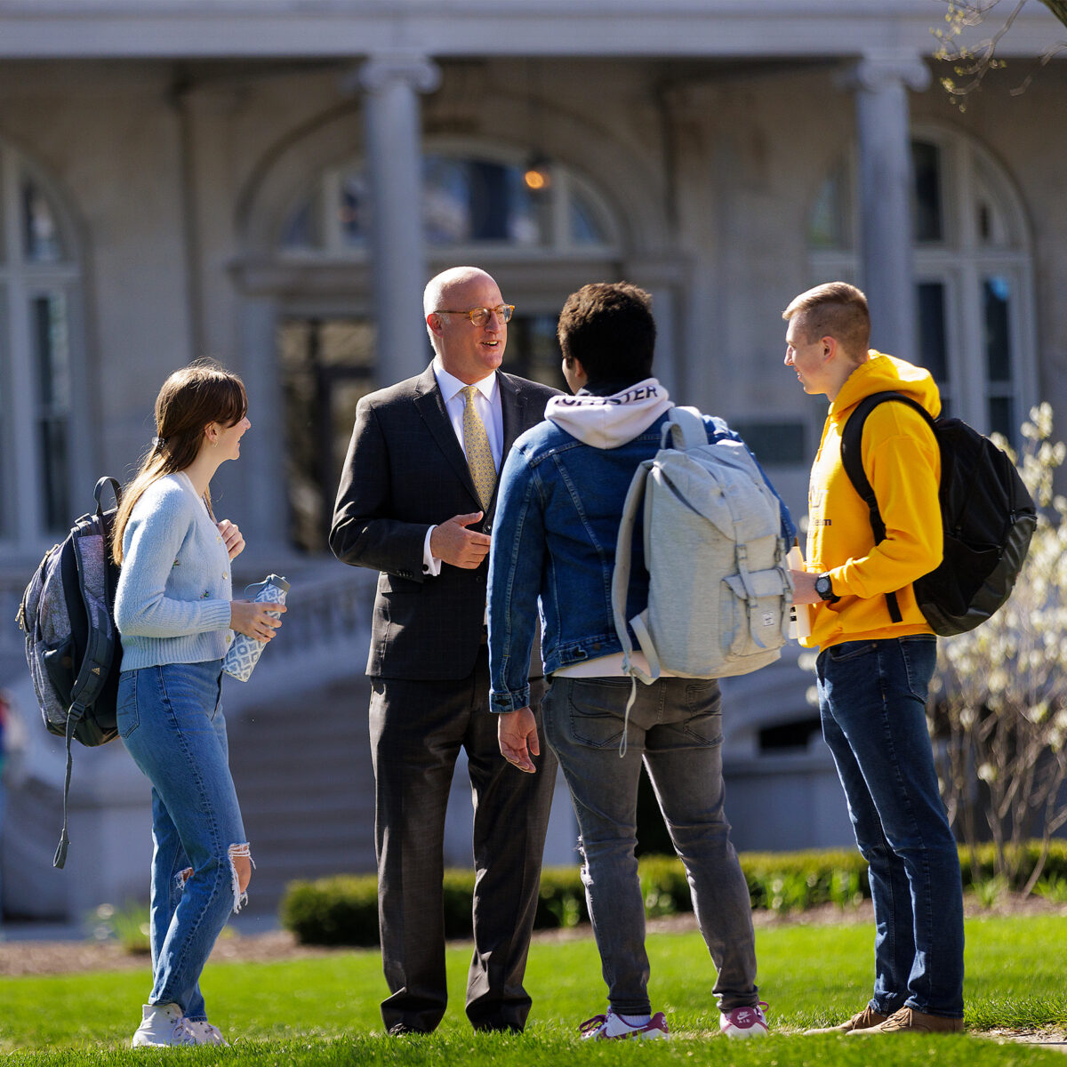 University president chatting with students