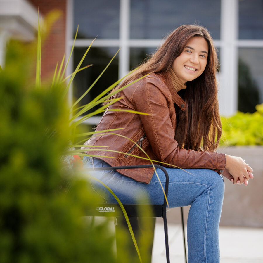Girl smiles while sitting on a bench