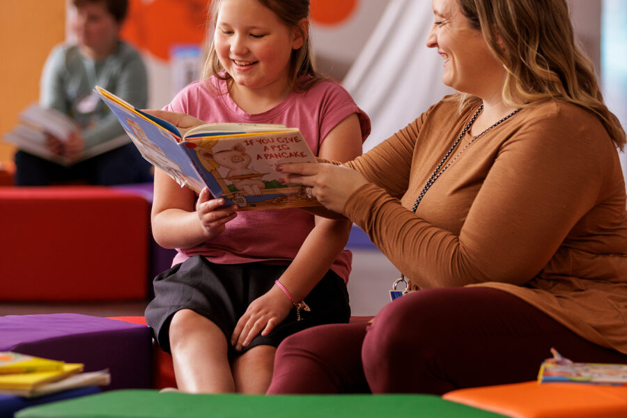 Photo of teacher reading a book to a child