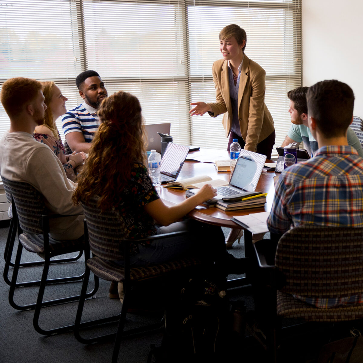 Student helping group of students complete assignment