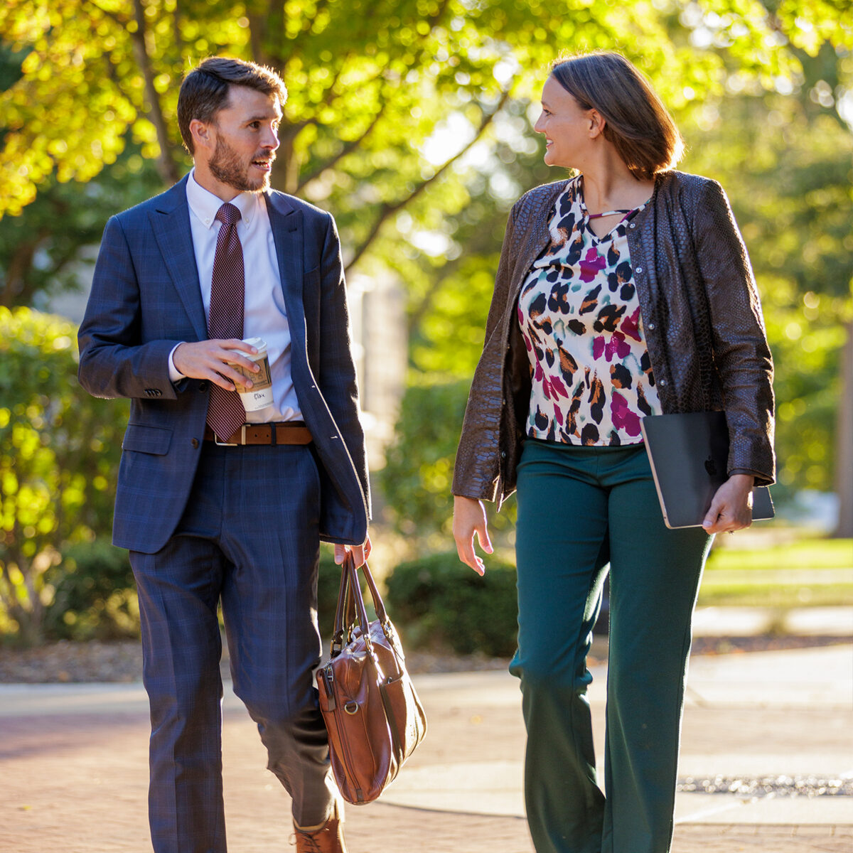 Two young professionals walking through the Quad