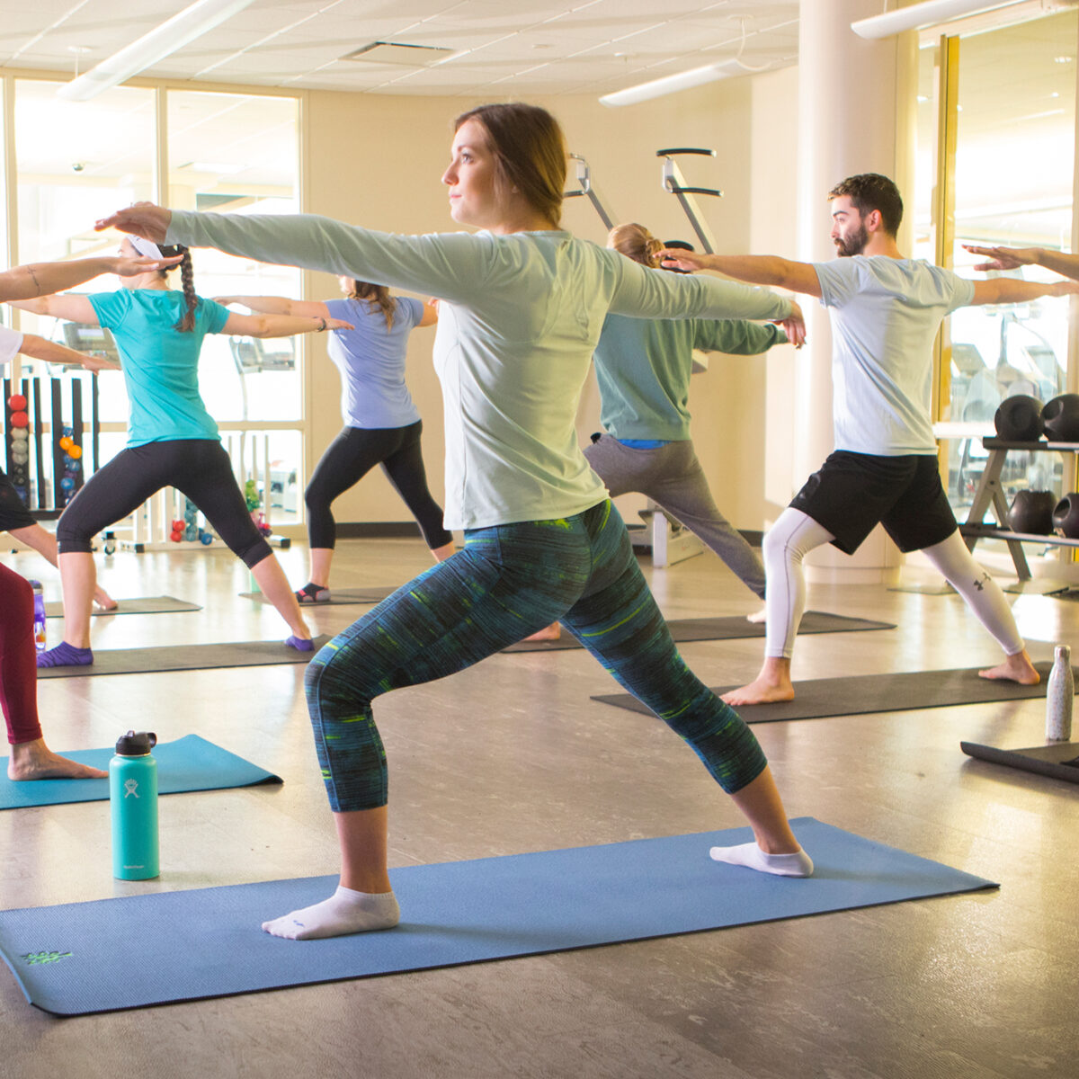 Group of students doing yoga in fitness center