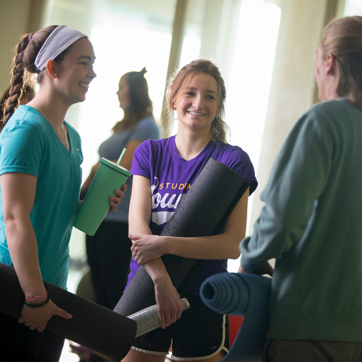 Group of friends holding yoga mats in Perry fitness center