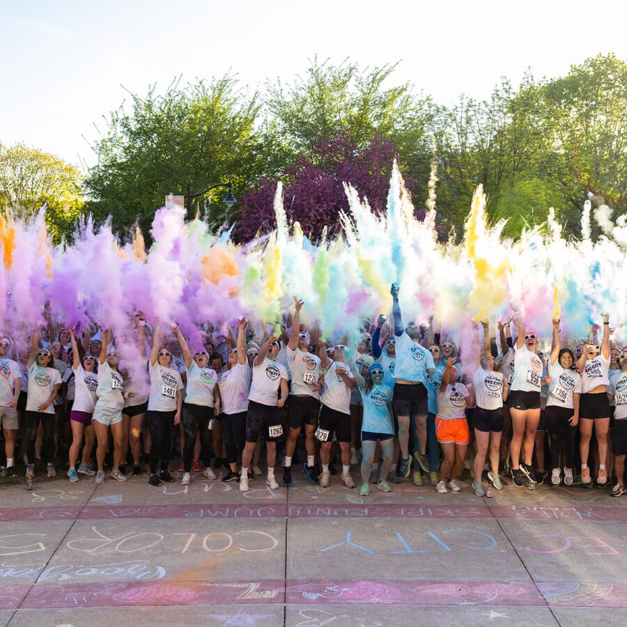 Students throw powder in the air before the 5K color run
