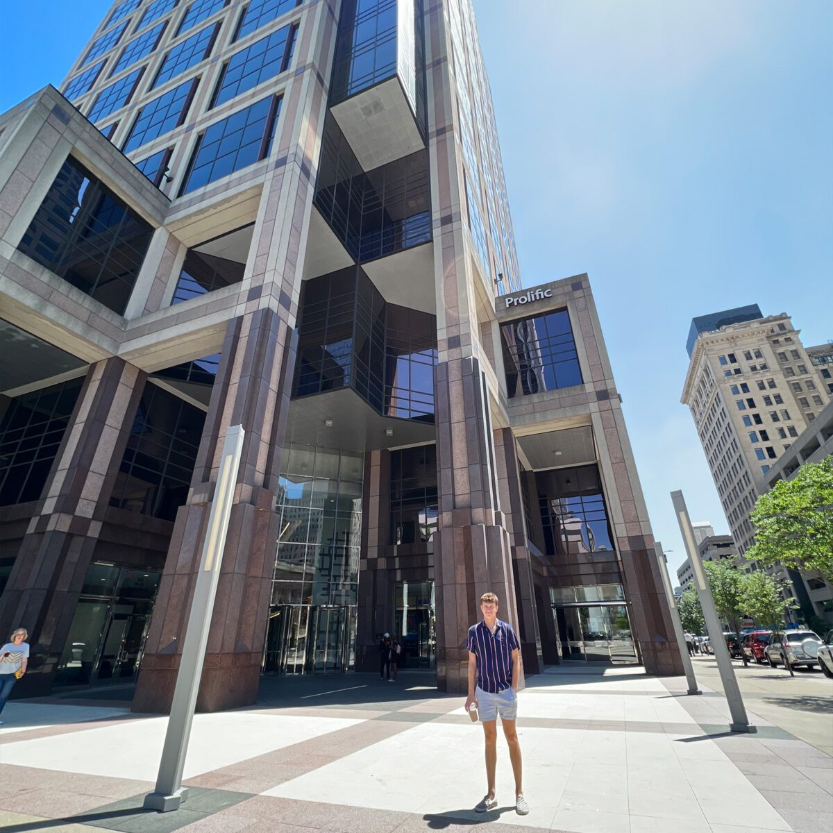 Student standing outside of skyscraper