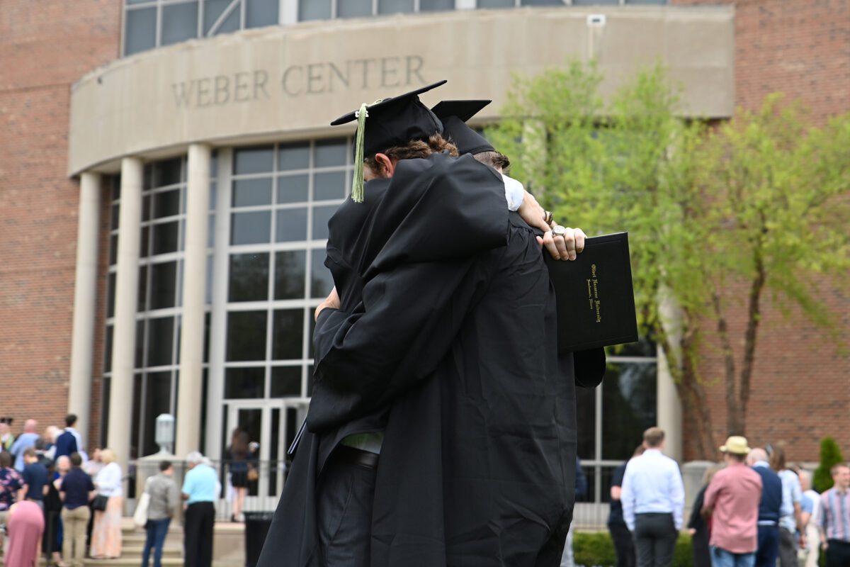 Two friends hug in celebration after the commencement ceremony.