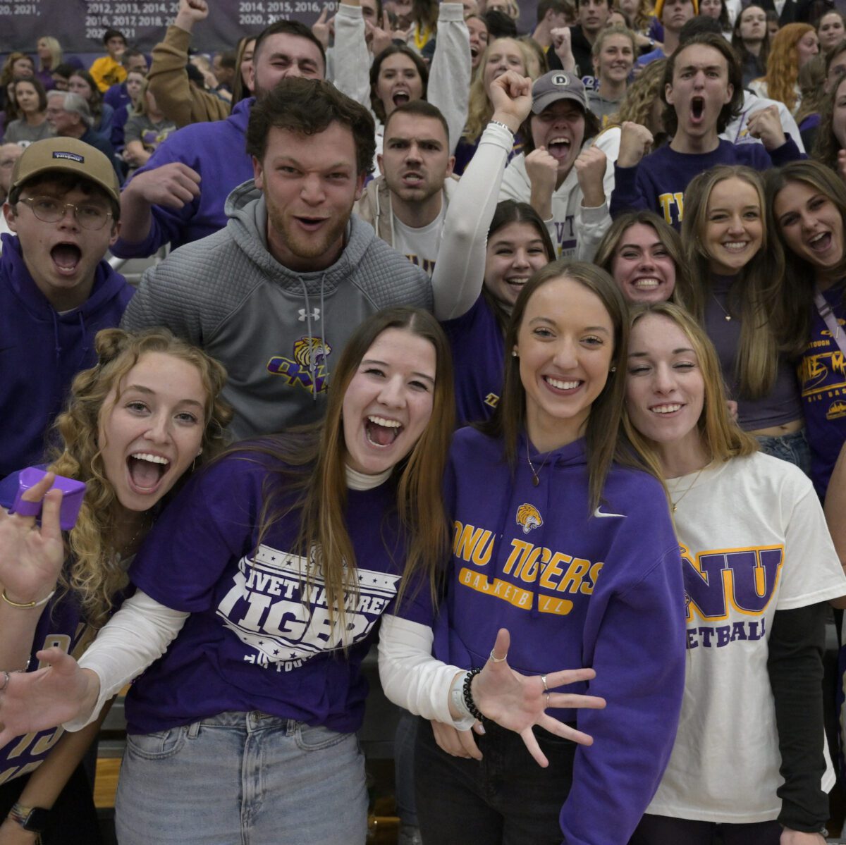 Excited students cheering at basketball game