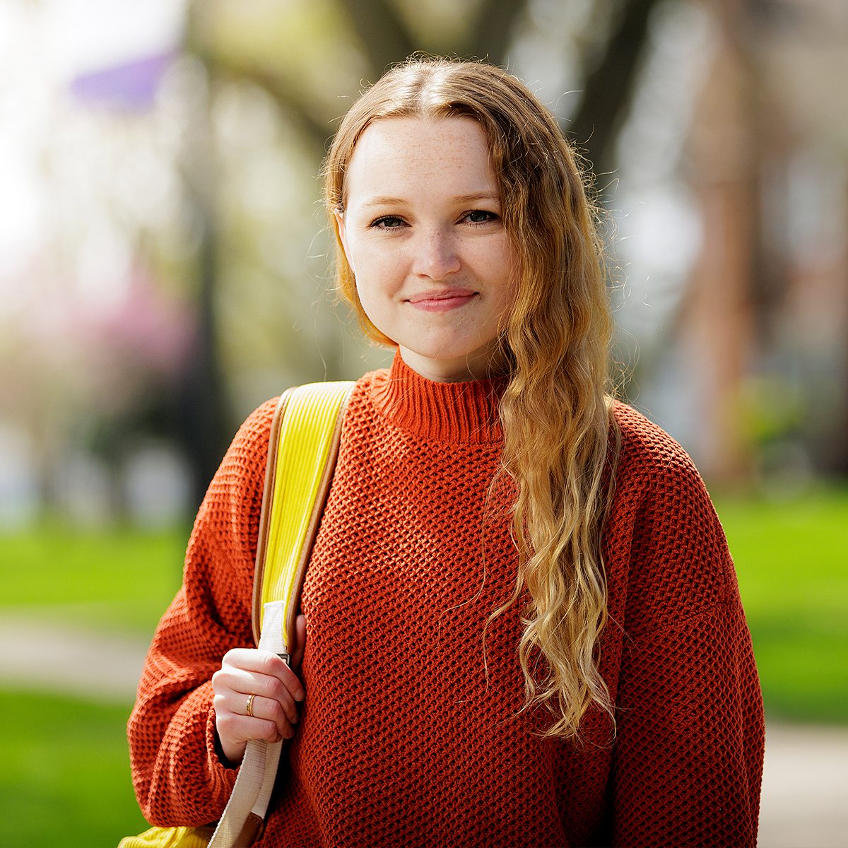 Student poses with her backpack