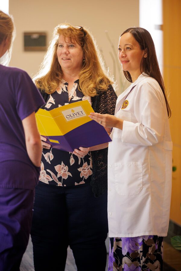 Nursing students engaging in conversation with a professor