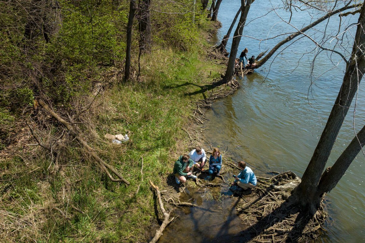 Group of students conducting an experiment by the river