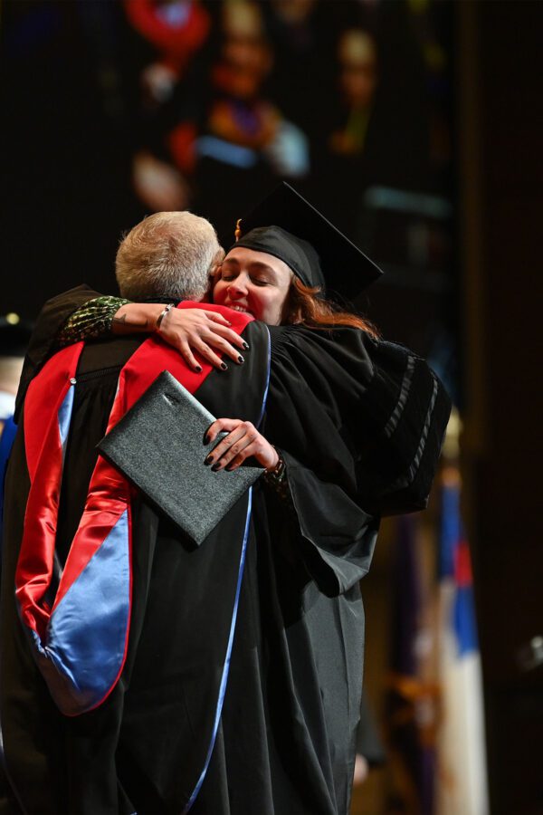 Professor congratulating graduate
