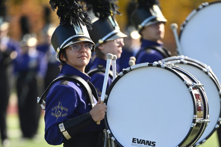 Three students smiling in marching band