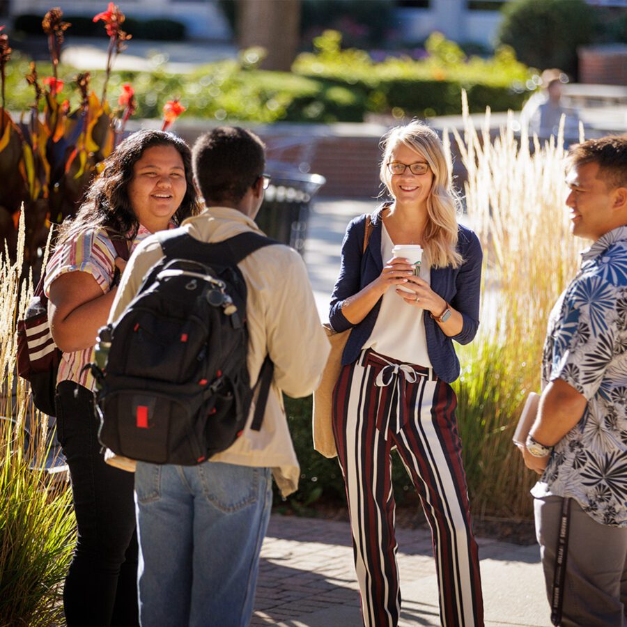 English professor conversing with three students