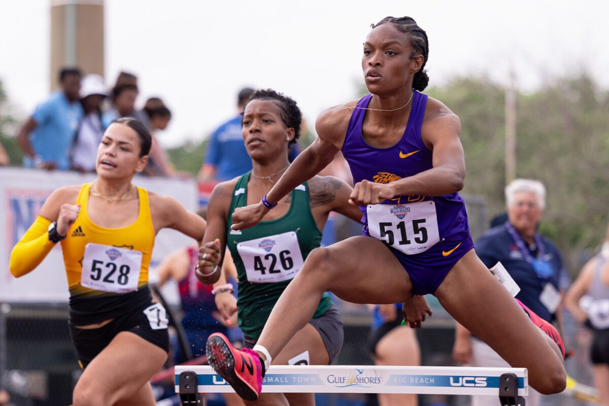 Female track clearing a hurdle
