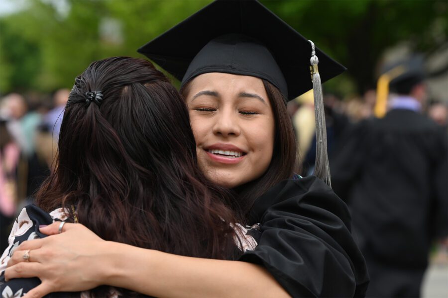 female student hugging parent at graduation