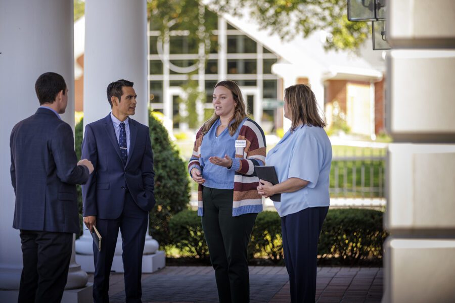 four people talking in front of Admissions