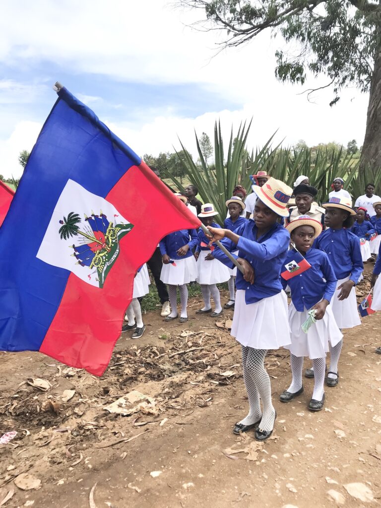 children from Haiti carrying the flag