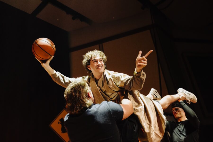 Young male holding a basketball and smiling