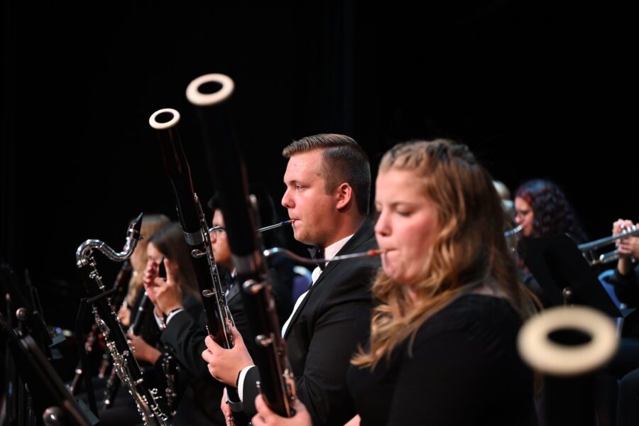 male and female student playing bassoons on stage