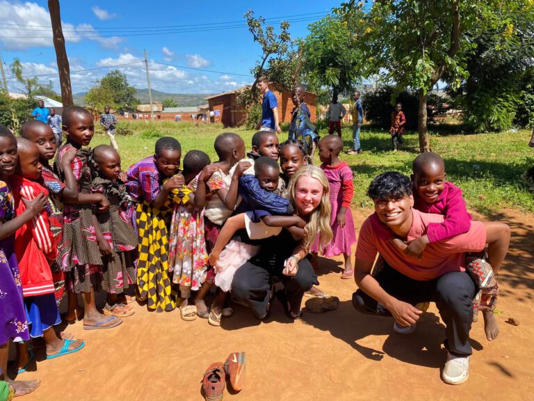 kids in Tanzania playing piggyback with Olivet students