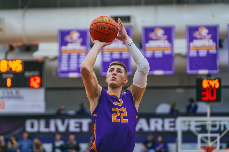 male basketball player shooting a ball into the net.