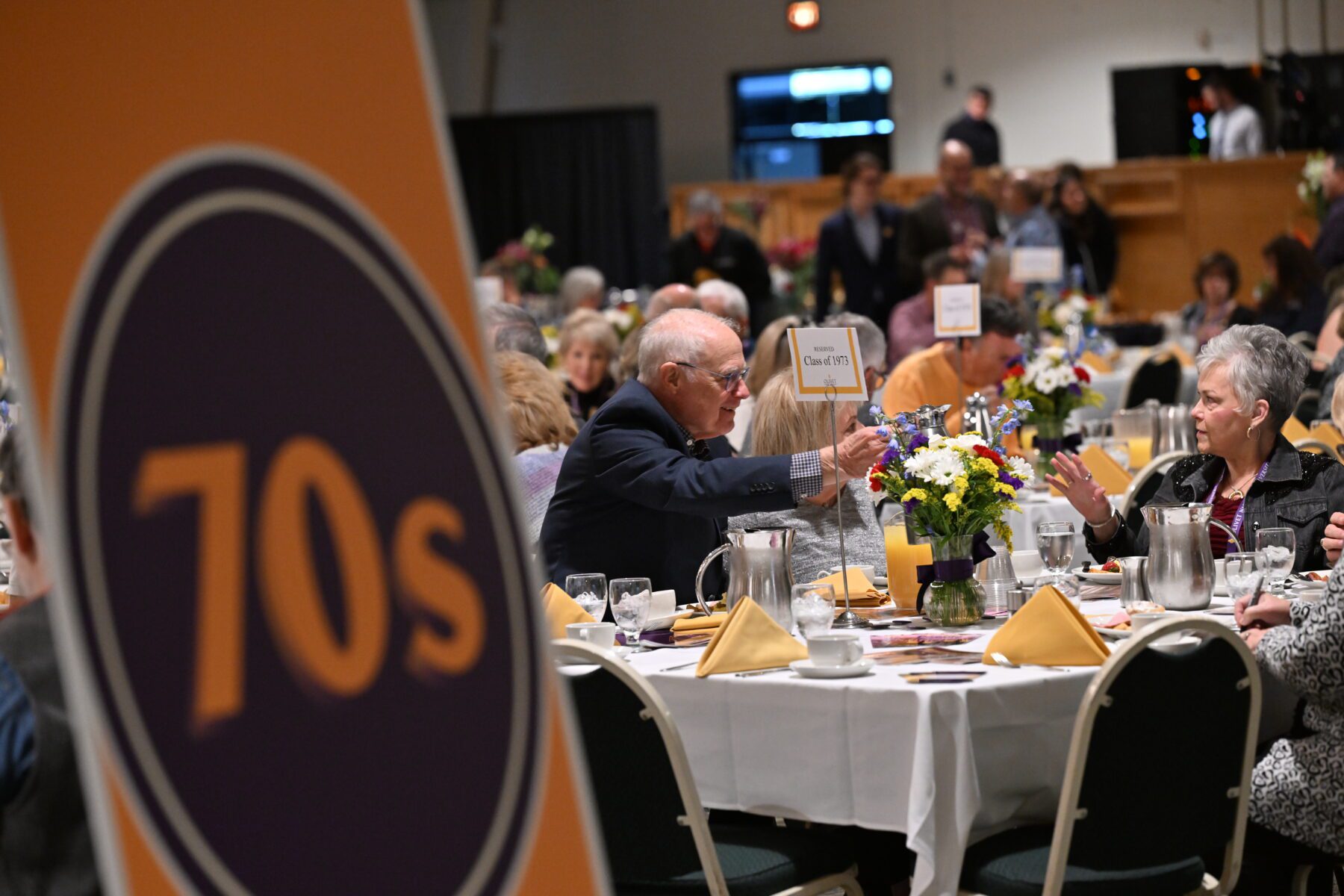 A group talks while sitting at the class reunion dinner.