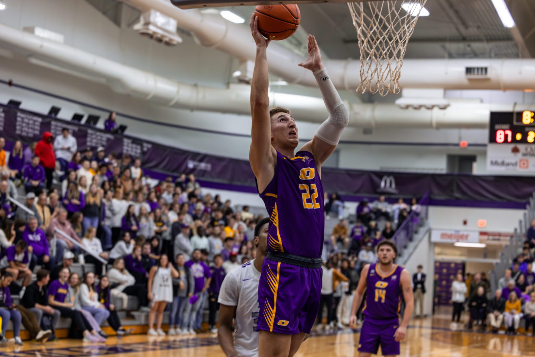 Olivet Men's Basketball player drives in to shoot a lay up.