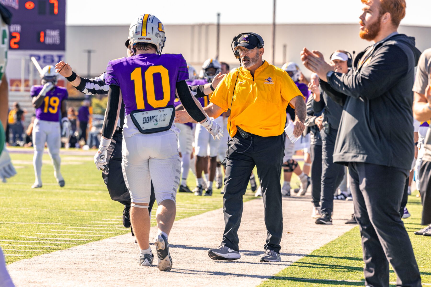 Olivet football coach encourages player with a high five.