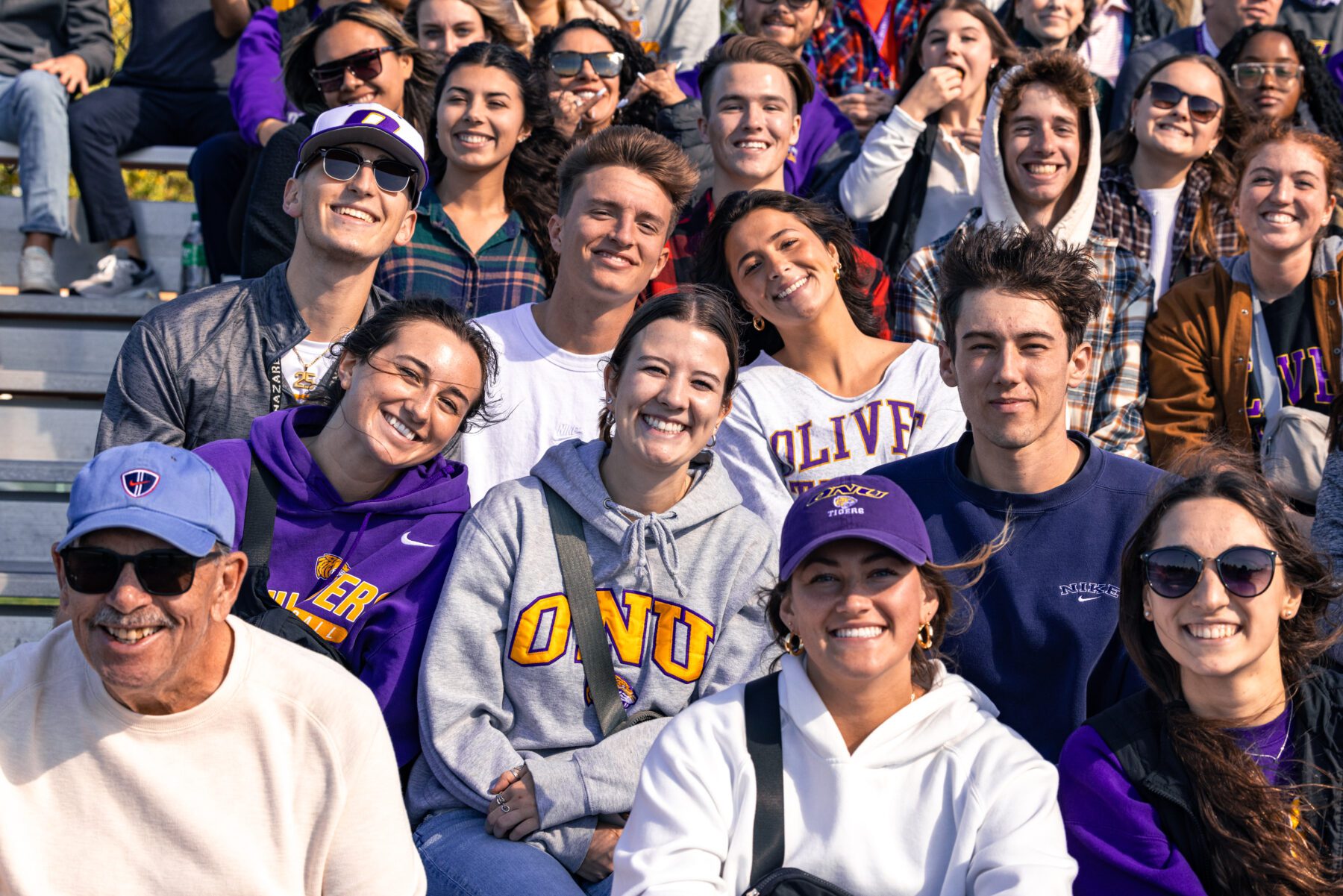 Students and Alumni sit at the Homecoming Football game.