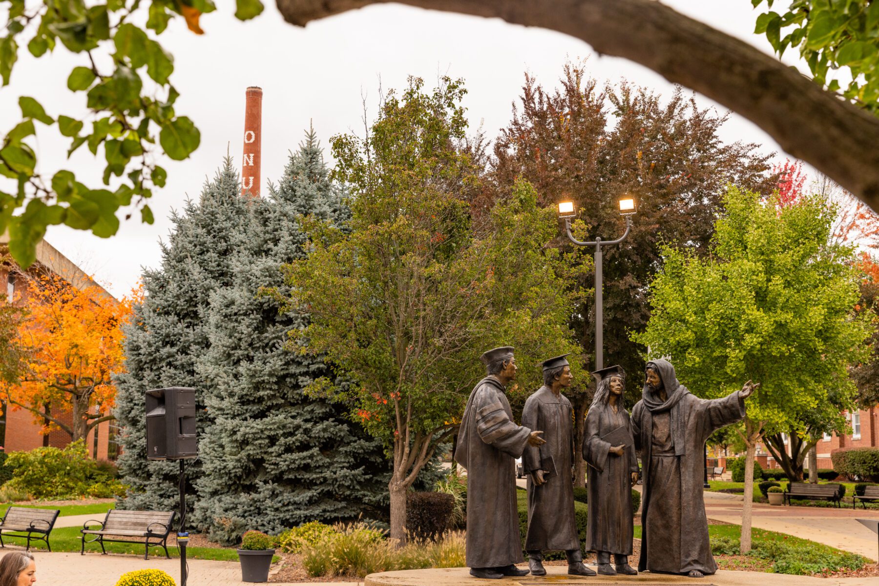 The statue stands in the quad of Olivet Nazarene University and points to Centennial Chapel.
