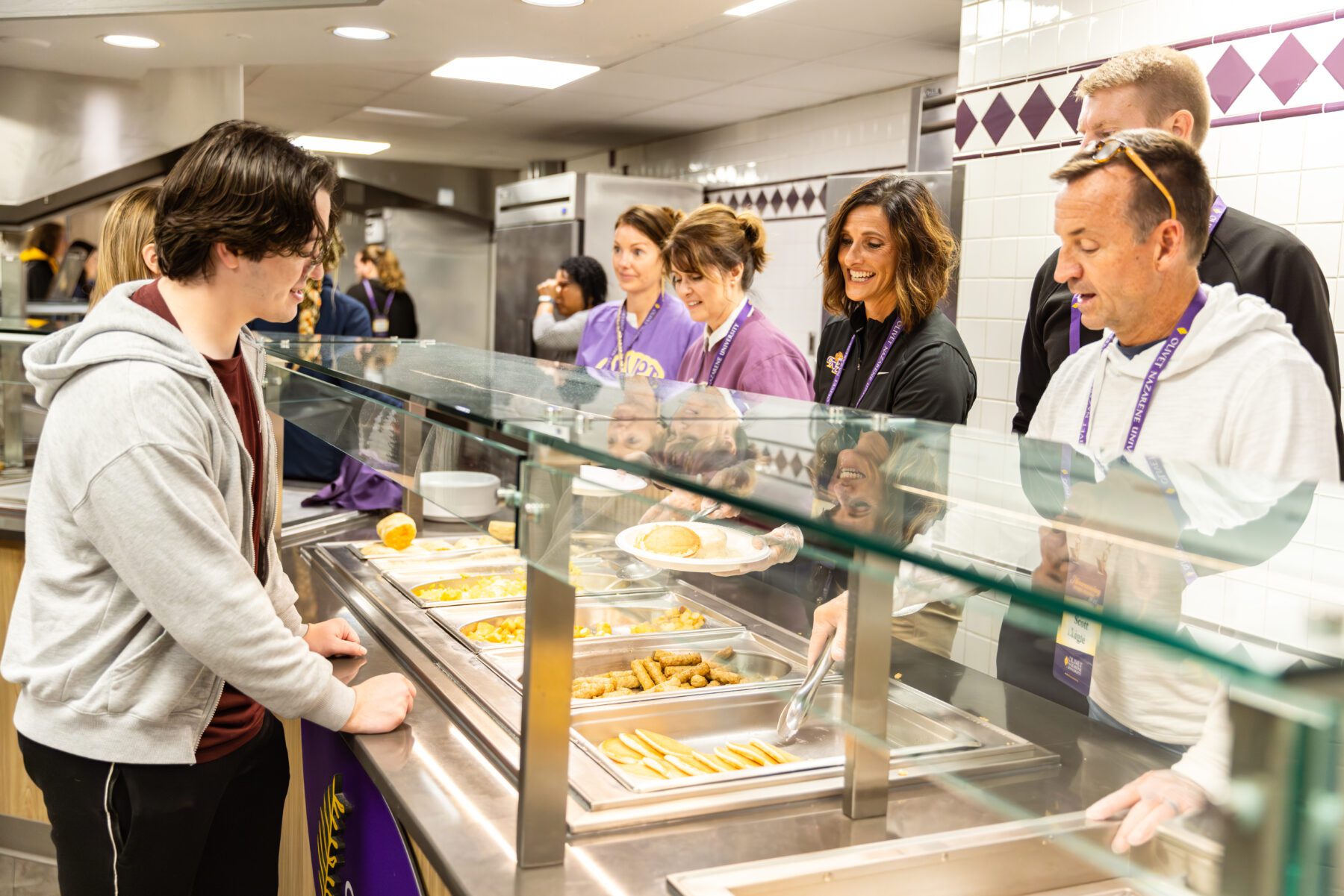 Alumni of Olivet serve the students coming through the line for a late night breakfast.