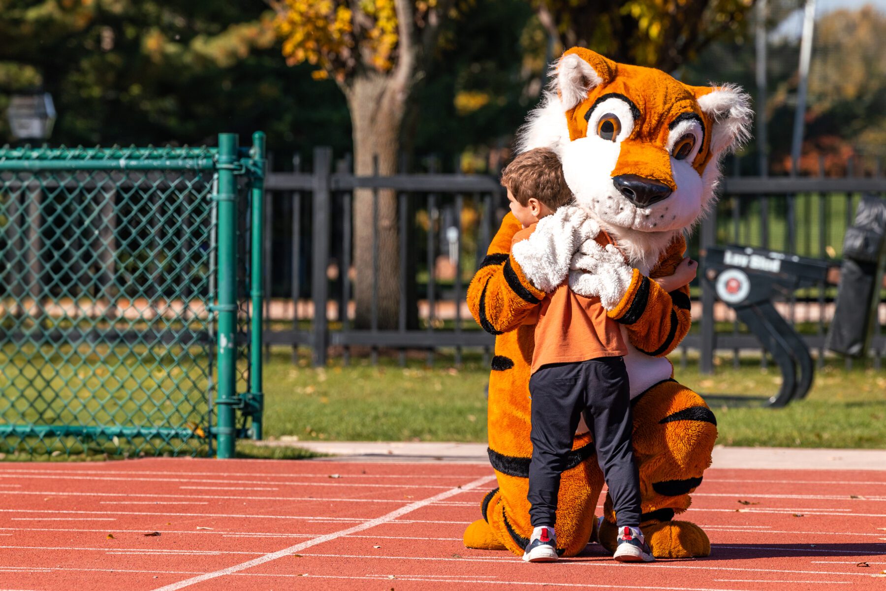 Toby the Tiger embraces a hug from a young boy.