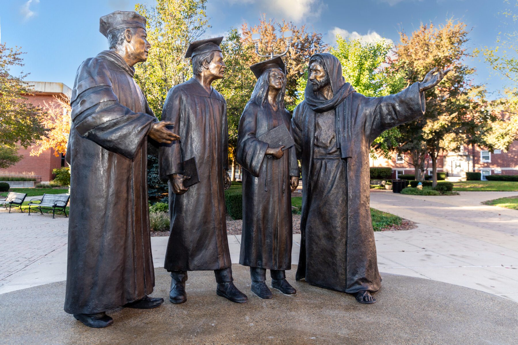 A picture of the new statue installed in the quad at Olivet nazarene University. It depicts Jesus leading the students of Olivet to the chapel where graduation happens.