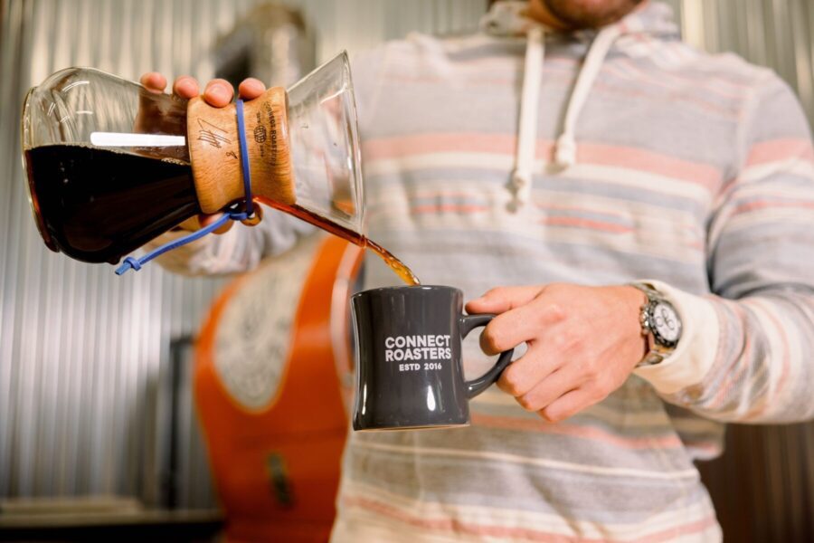 man pouring coffee into connect roasters cup