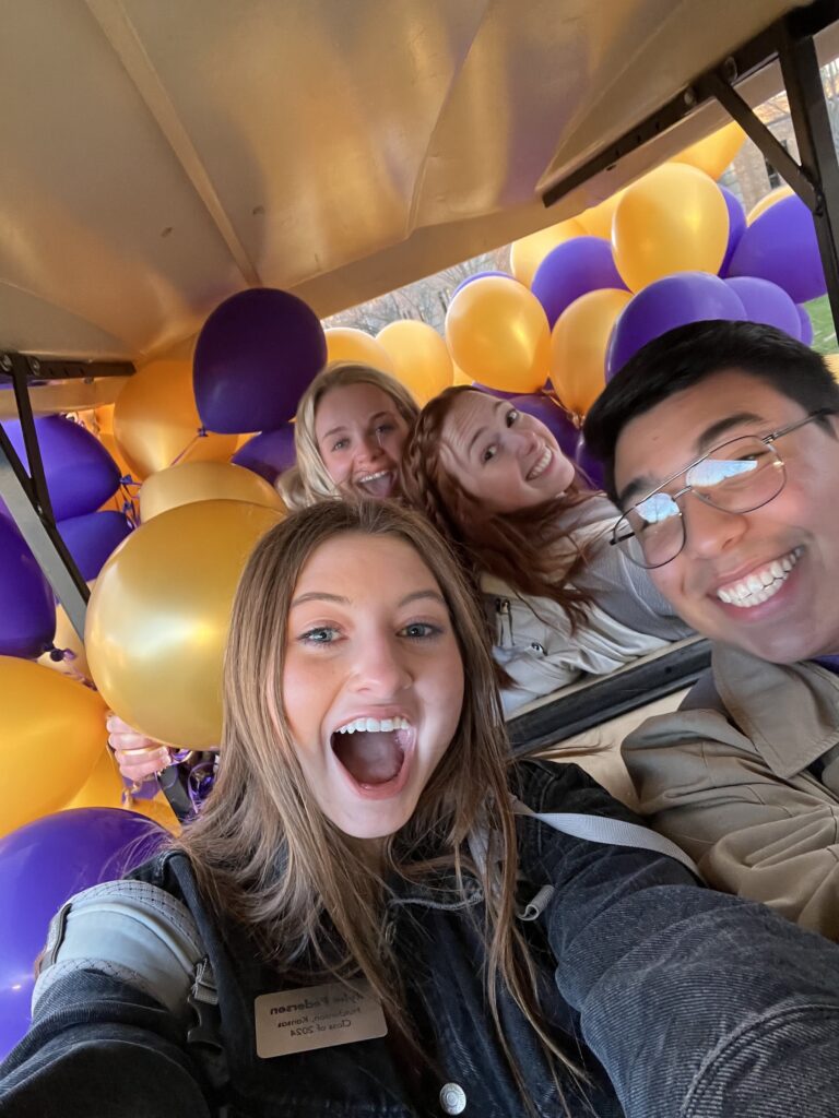 Admissions ambassadors on golf cart with balloons